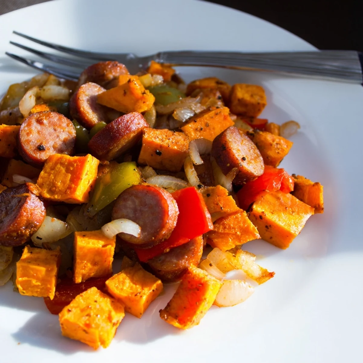 Hearty Sweet Potato & Cajun Sausage Hash with vibrant peppers and savory spices.  