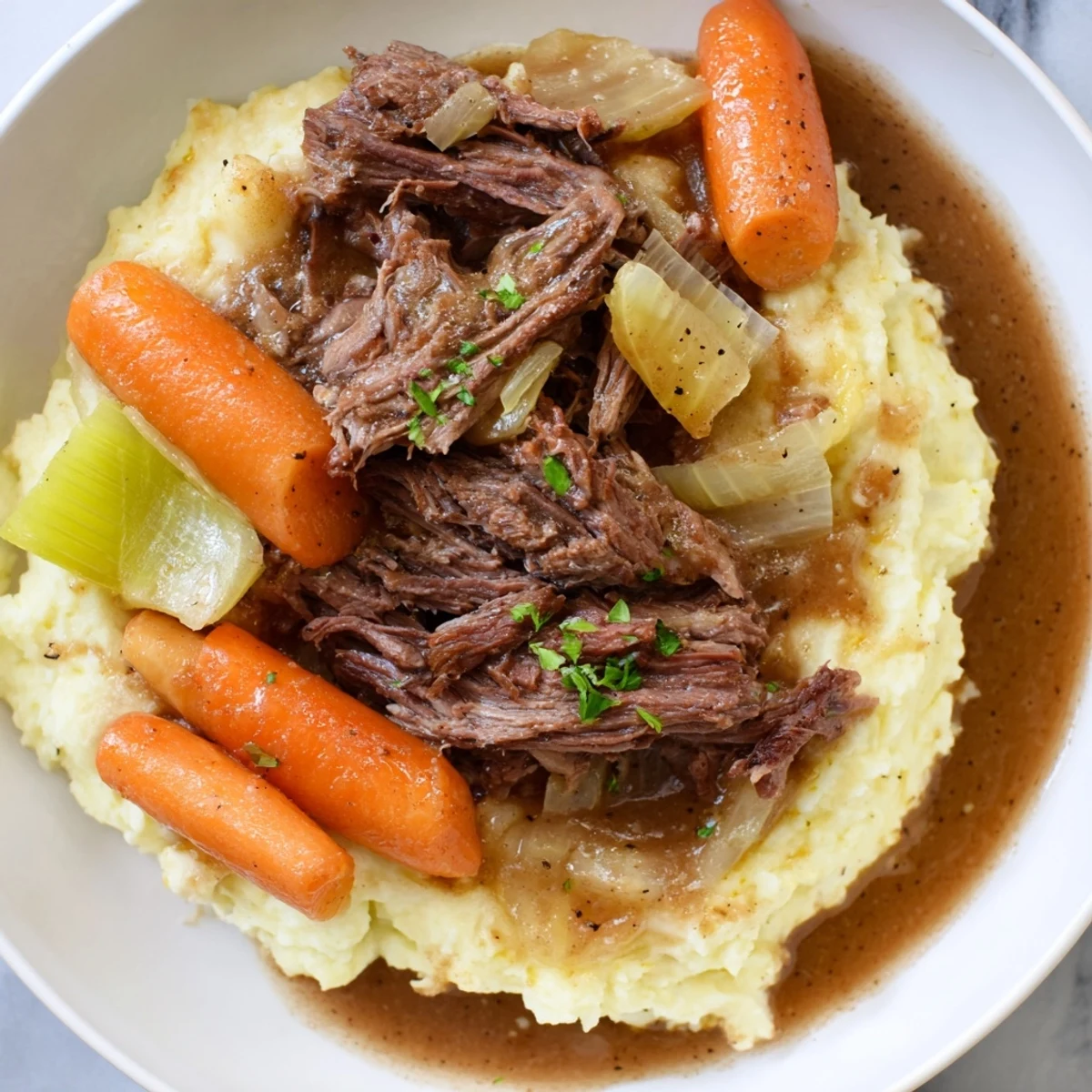 Close-up of a flavorful Slow Cooker Pot Roast, showcasing soft beef and delicious mashed potatoes.