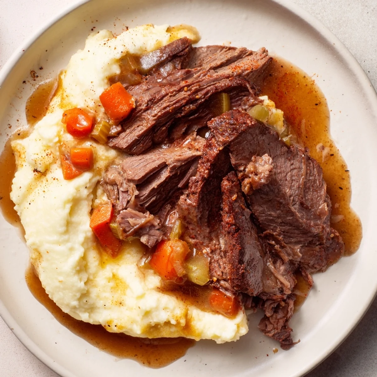 A close-up of tender, sliced Classic Brisket served with fluffy, golden mashed sweet potatoes.