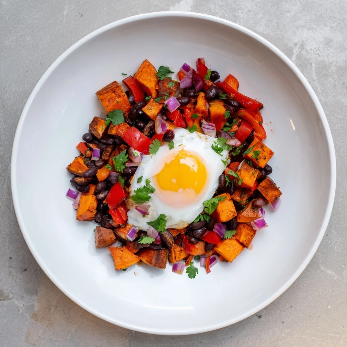 Enjoy a steaming skillet of flavorful Sweet Potato & Black Bean Breakfast Hash for a hearty, healthy meal.