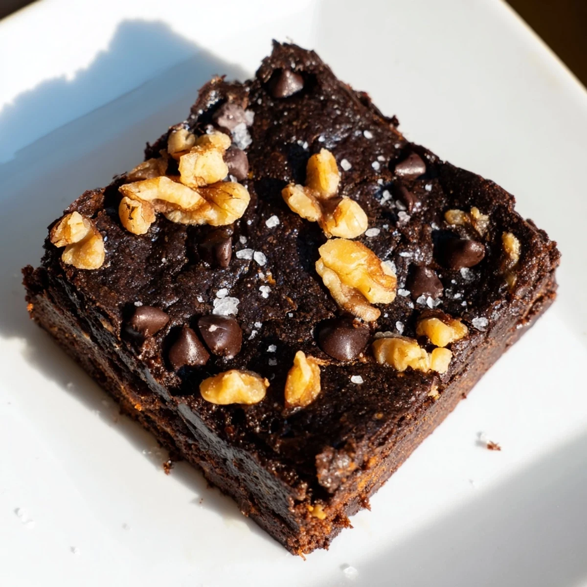 Warm, fudgy sweet potato brownies topped with dark chocolate chips, ready to slice and serve.