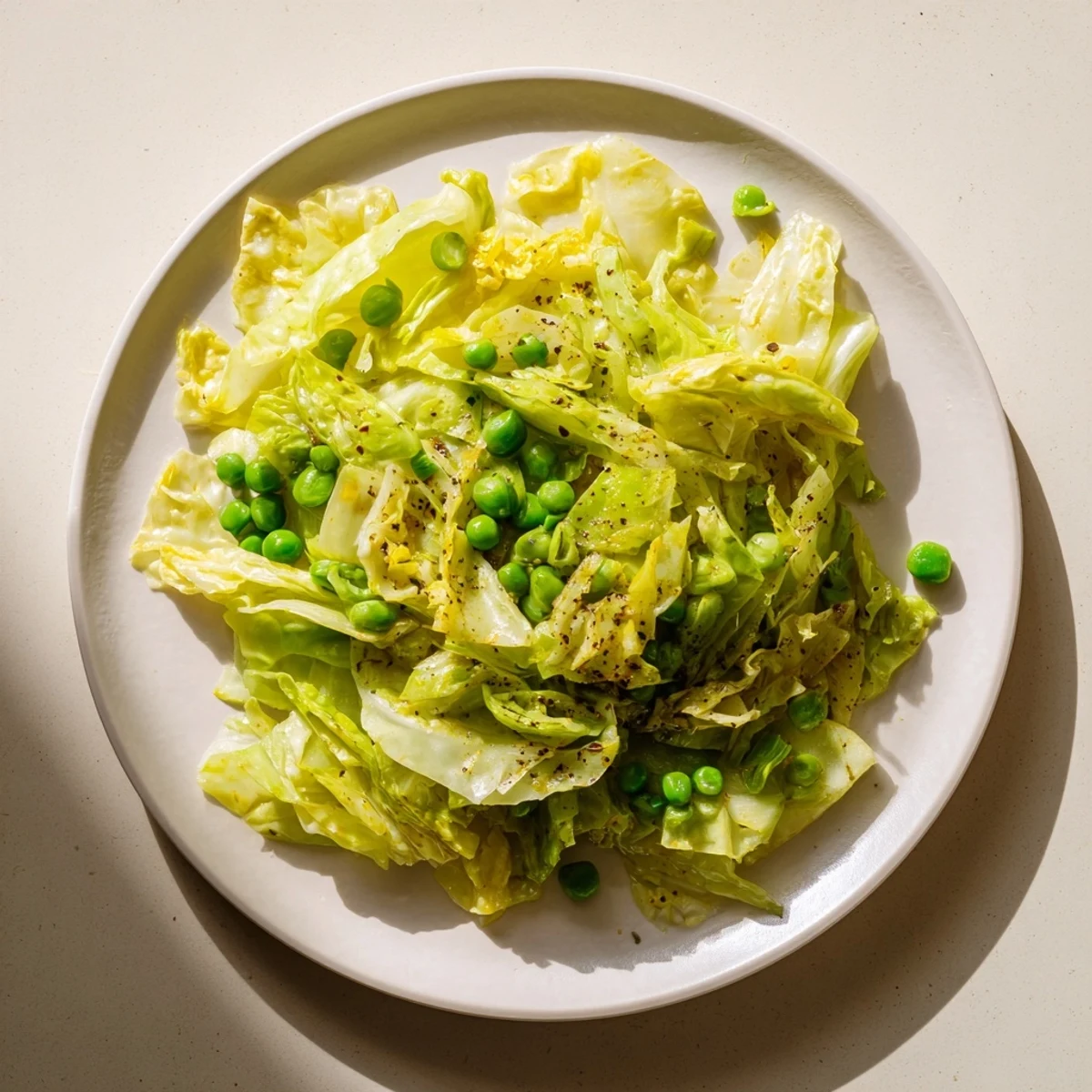 Steaming cabbage stir-fry with garlic, soy, and peas, ready to serve as a vegetarian side.