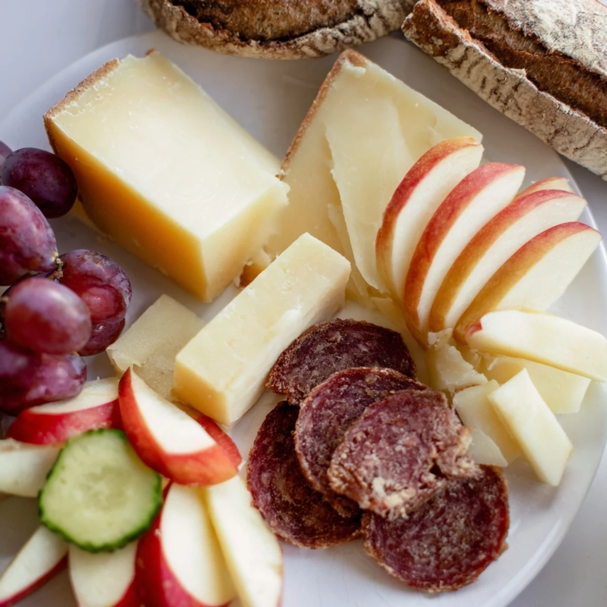 This delicious Planche Montagne Aventure Collation includes crusty bread, grapes, and various gourmet snacks.