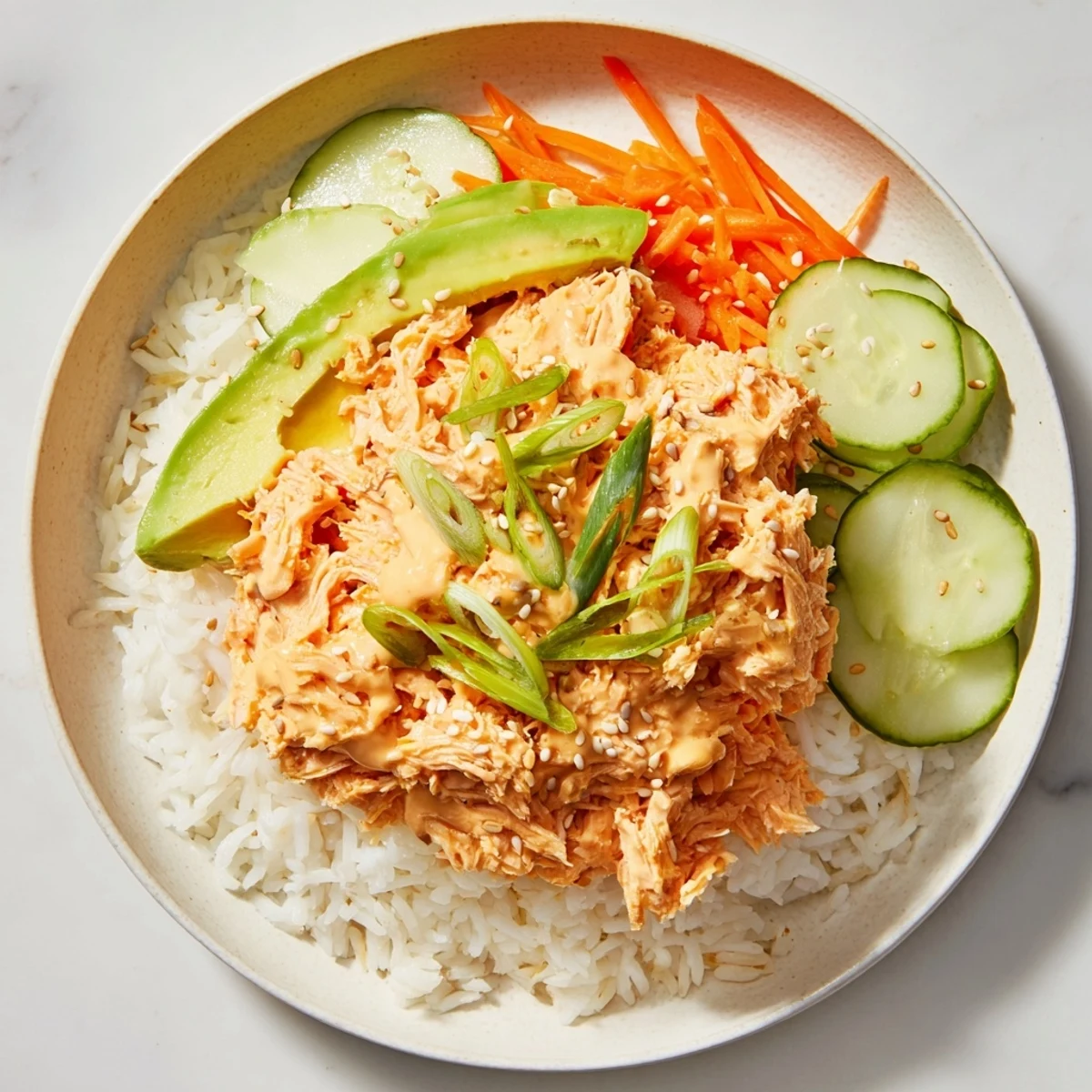 A flavorful spicy canned salmon rice bowl, showcasing creamy sriracha-infused fish and fresh toppings.