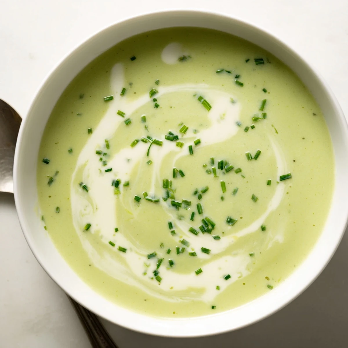 Creamy broccoli soup simmering in a pot, revealing a velvety texture with broccoli, carrots, and onions cooked in broth.