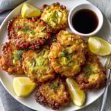 Close-up view of crispy, golden-fried Tempura Sweet Corn Zucchini Fritters, showing the tender vegetable filling.