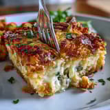 Cheesy jalapeño funeral potatoes with golden cornflake topping and creamy potato base in a baking dish.