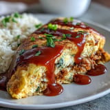 Fluffy omurice glistening with ketchup sauce, a popular Japanese comfort food dish.