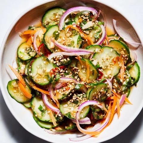 Fresh and tangy cucumber salad remix with colorful veggies and savory dressing.  