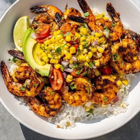 Grilled shrimp bowl overflowing with colorful avocado corn salsa and tender, juicy shrimp.