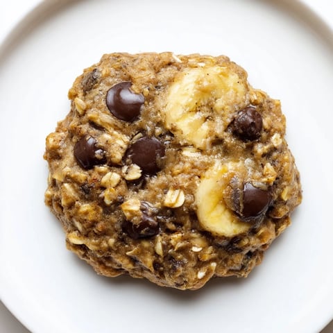 Warm, soft Oat-Banana Chocolate Chip Cookies, golden edges, ready to enjoy with a glass of milk.