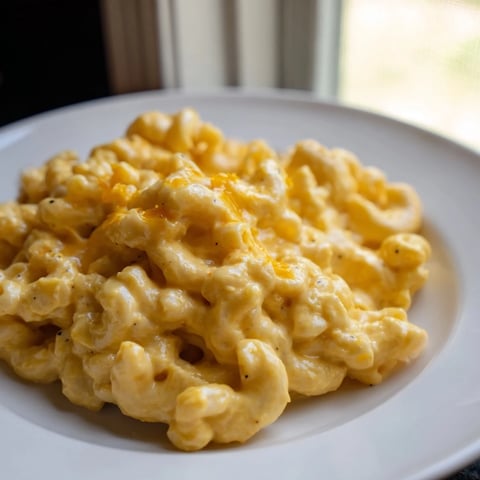 A steaming bowl of one-pot butternut squash mac & cheese, garnished with melted cheese and ready to eat.