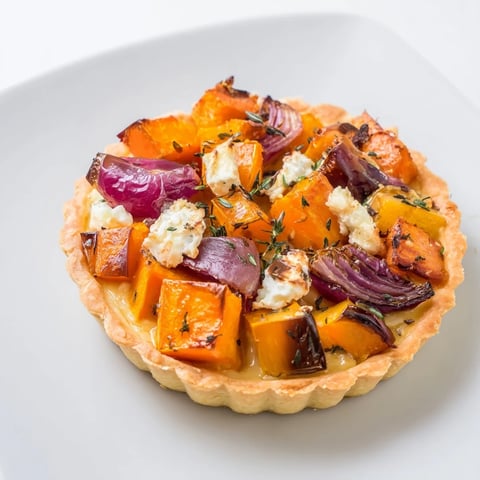 Golden-brown Feuilles dÉrable Tartes Salées dAutomne, a flaky tart filled with roasted vegetables.