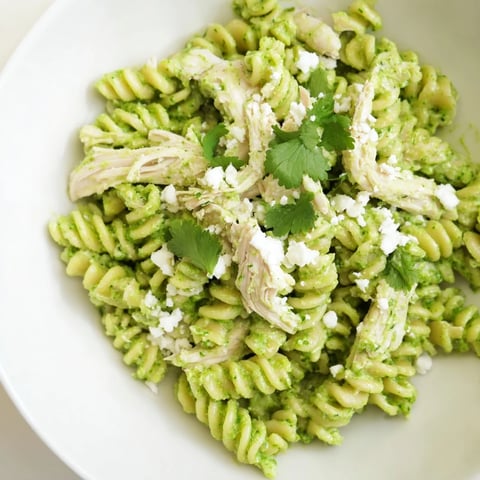 A vibrant bowl of Cilantro Lime Chicken Pasta features creamy green sauce clinging to golden rotini and tender chicken.  