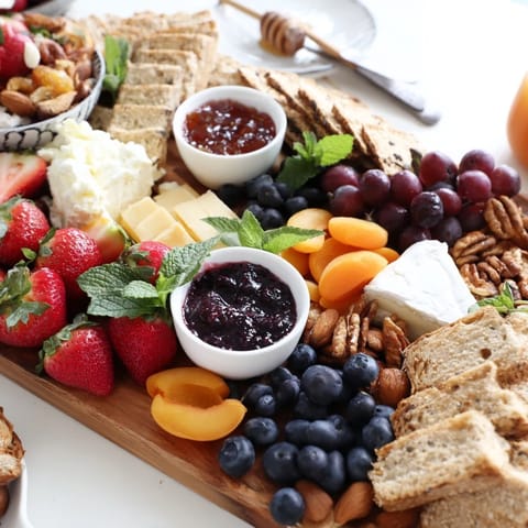 Visualize a jam-infused brunch board filled with fruits, cheeses, and breads.  