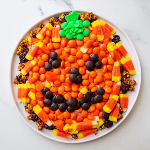 A festive arrangement of a Jack-o-Lantern candy board, featuring bright orange and black sweets.