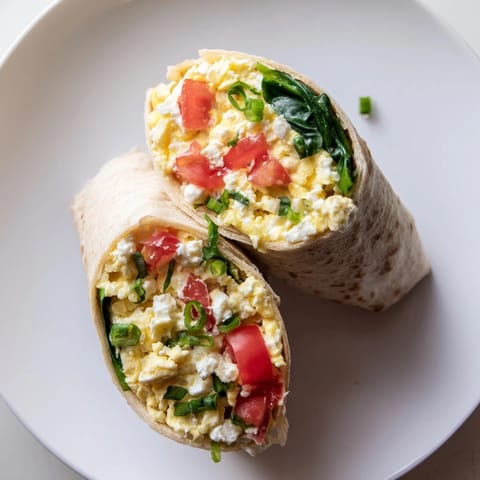 Ready-to-eat feta egg wraps showcasing creamy feta cheese and vibrant green vegetables for breakfast.