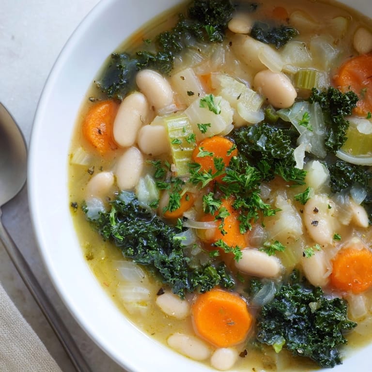 Ladling hot White Bean and Kale Soup garnished with fresh parsley. Comforting and delicious.