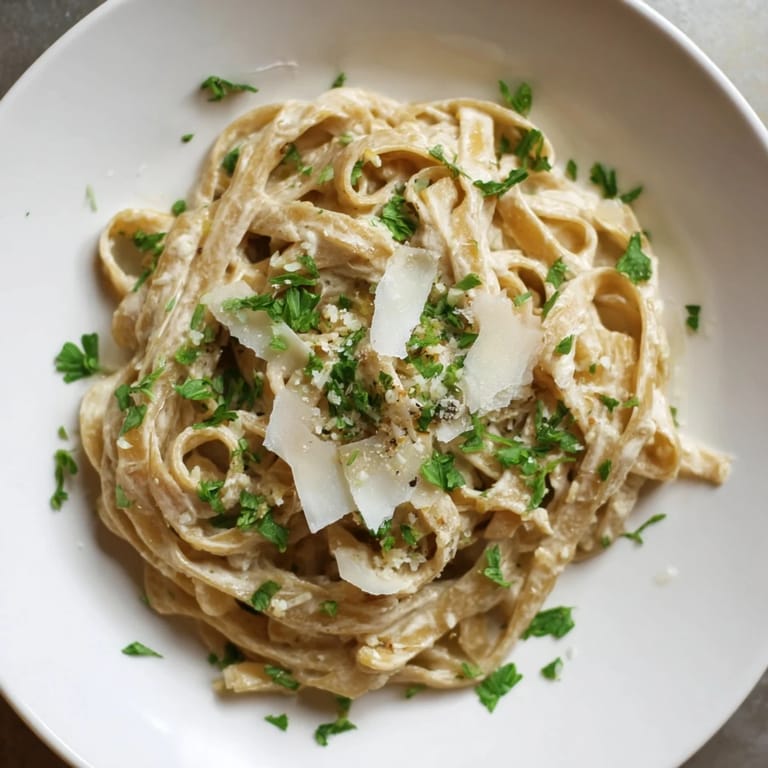 Velvety Skinny Alfredo Garlic Parmesan Snowy Pasta, coated with a garlic-Parmesan sauce.