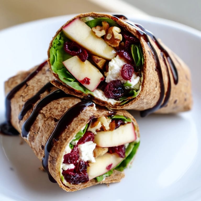 Close-up of a sliced Cranberry Goat Cheese & Walnut Wrap, hinting at its delicious, fresh ingredients.