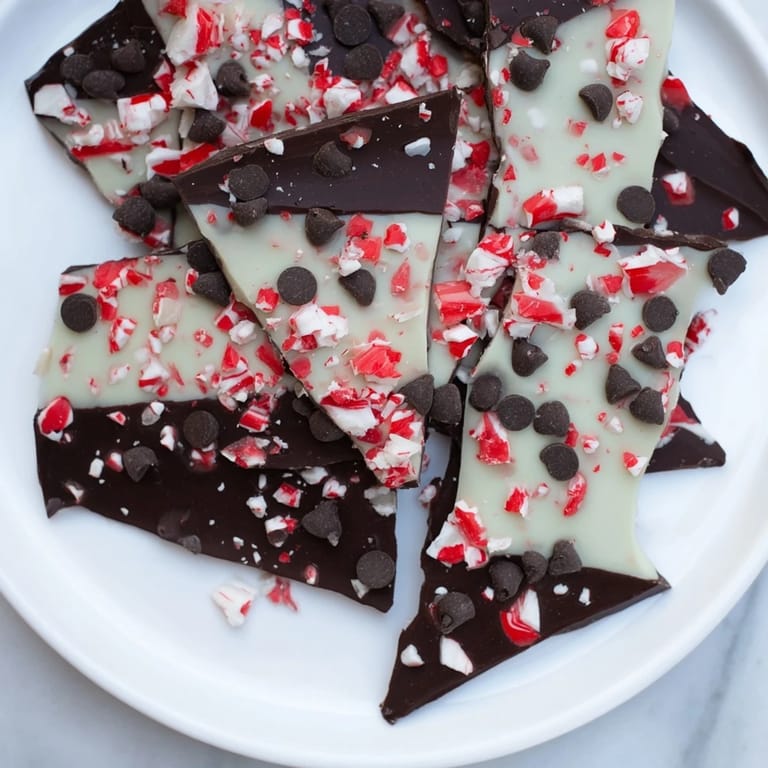 Freshly made peppermint bark shards glistening with crushed peppermint, perfect for holiday gatherings.
