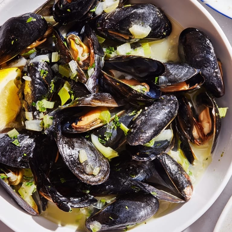 Delicious Belgian Moules Marinière, ready to serve in bowls, brimming with briny, flavorful broth.