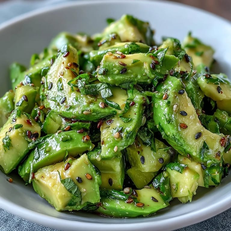 Creamy smashed cucumber avocado salad piled high with green onions and sesame.