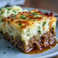 Classic Shepherds Pie with Cauliflower Mash Topping in a golden-brown baking dish, topped with creamy mashed cauliflower and hearty lamb filling bubbling beneath.