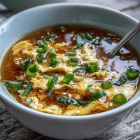 Silky homemade egg drop soup with delicate ribbons of egg in savory broth and fresh scallions.