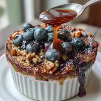 Warm baked oats with juicy blueberries, maple syrup, and banana in a single-serve ramekin. Perfect healthy breakfast.  