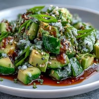 Vibrant smashed cucumber avocado salad with sesame seeds, a fresh, zesty fusion dish.